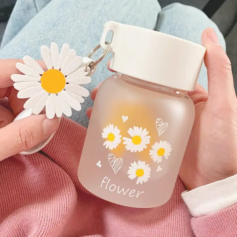 A frosted glass daisy flower glass water bottle with white lid and paper flower charm by decorbites daisy flower