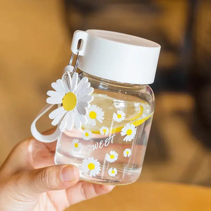 Clear glass daisy flower glass water bottle with white and yellow decals white lid and daisy charm decorbites daisy flower