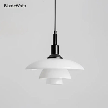 Danish tiered frosted glass pendant light with black and white brass fixture serving as a modern dining room focal point