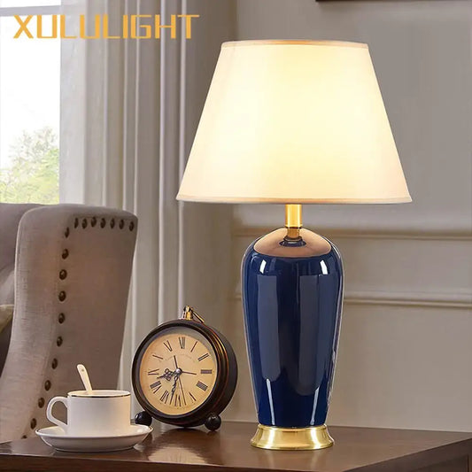 Dark blue ceramic table lamp with remote control featuring gold-toned base and cream fabric shade for bedroom decorbites