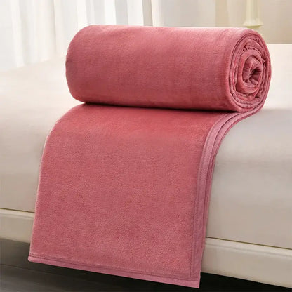 A dusty rose plush fleece blanket rolled over a white surface complementing decorbites cozy flannel sofa cover