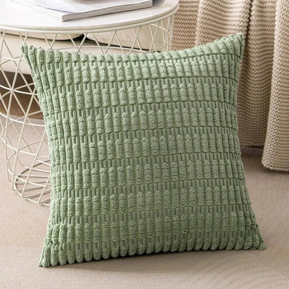 A soft sage green textured throw pillow with a raised woven pattern complementing decorbites corduroy striped cushion cover