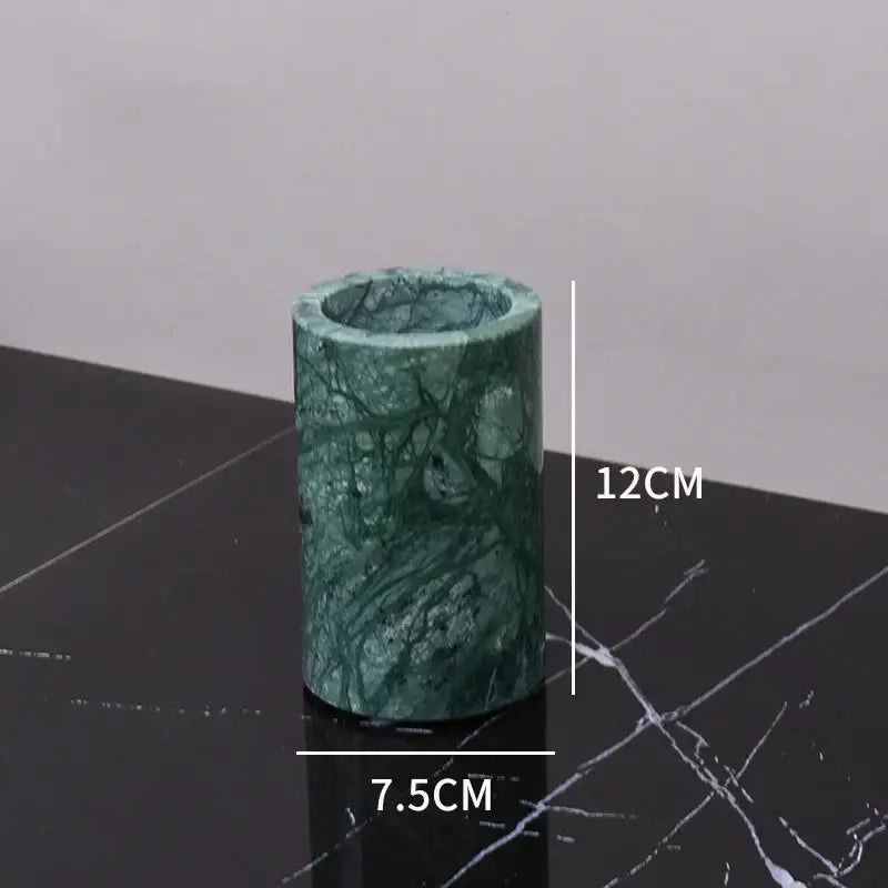 A cylindrical dark green marble candle holder with polished surface and natural veining from decorbites bathroom set