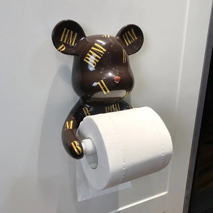 Brown bear-shaped resin paper towel holder with gold hm lettering and glossy finish holding white toilet paper roll
