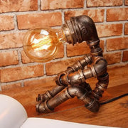 DecorBites 1-light industrial robot table lamp with antiqued bronze metal articulated body and exposed filament bulb