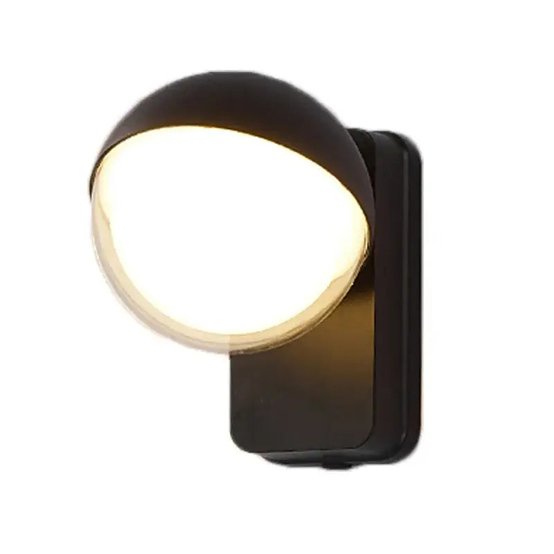 Modern black spherical wall lamp with motion sensor emitting warm glowing light for porch use