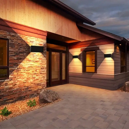 Modern black minimalist 24w led wall light outdoor sconce illuminating the entrance of a home with rectangular design