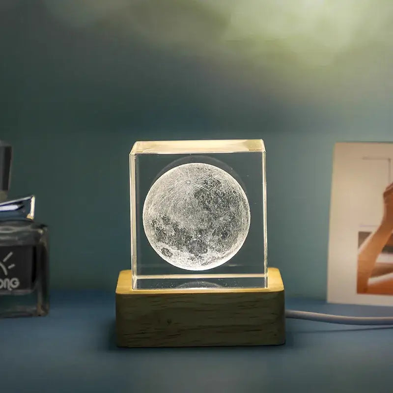 The decorbites 3d moon glowing night light features a detailed moon inside a clear glass cube on a wooden base