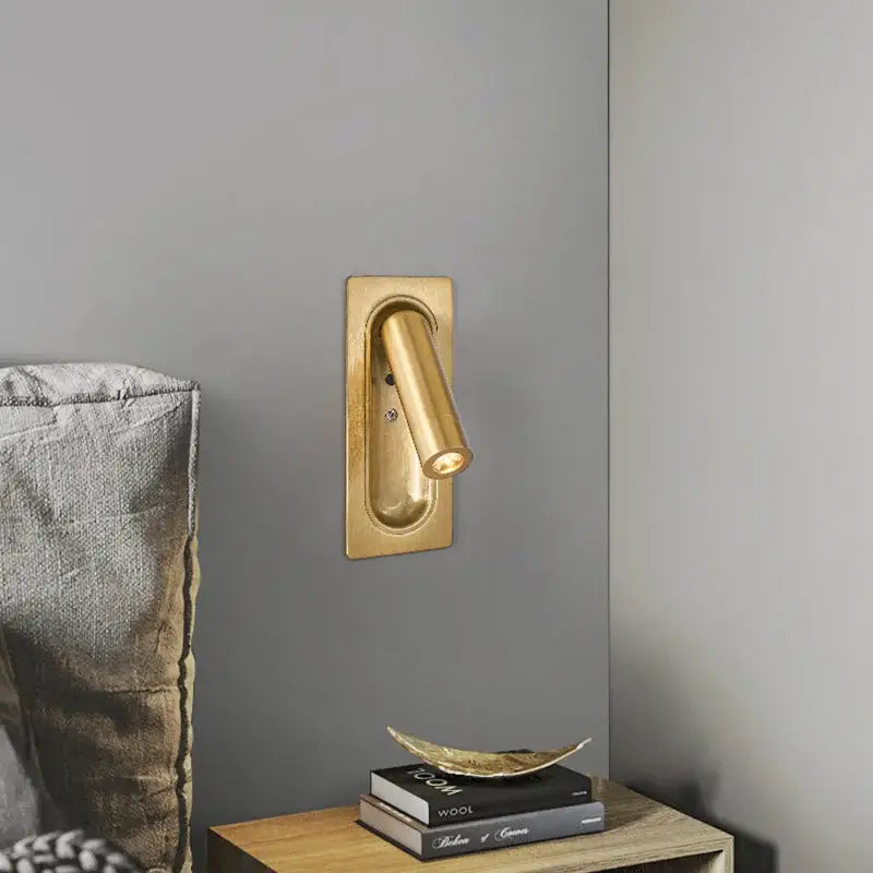 Modern brass and black led mounted headboard wall light with gold-finished cylindrical head and rectangular base decorbites 3w led wall light