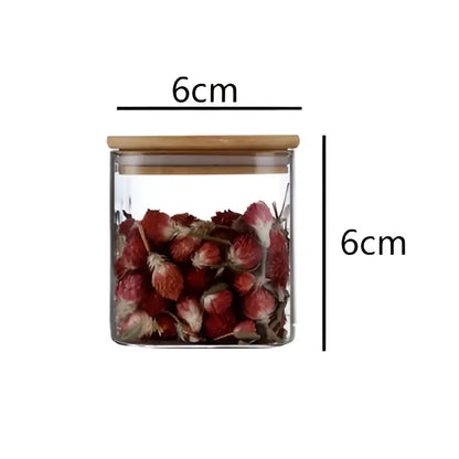 A clear 6cm glass jar from DecorBites 5oz glass set with bamboo lid filled with dried red flowers