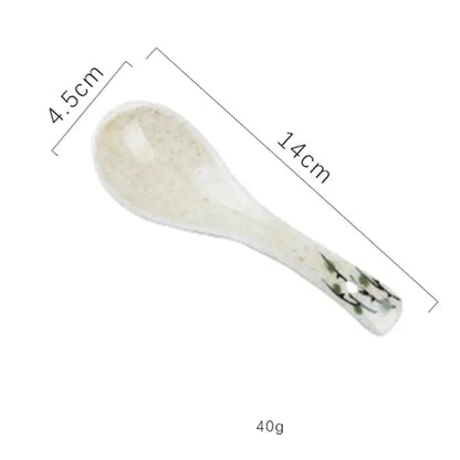 A delicate white ceramic spoon with speckled finish and green floral design for the decorbites ceramic ramen bowl