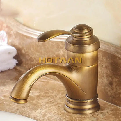 Antique brass basin faucet with single handle curved spout and decorative ridged base for bathroom use