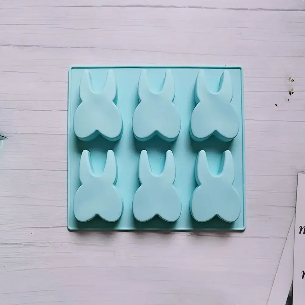 Light blue silicone mold with six bunny-shaped holes from decorbites™ 6 hole tooth silicone bakeware