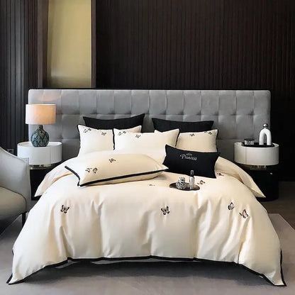 Cream-colored satin duvet set with black butterfly embroidery and piping made from 600tc egyptian cotton by decorbites
