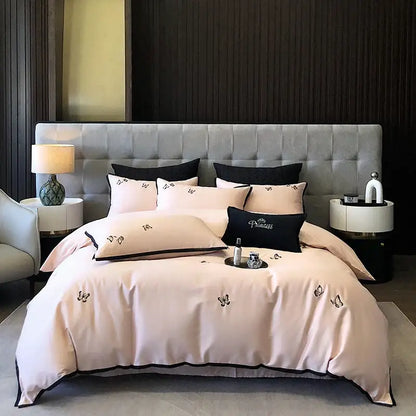 A blush pink satin bedding set with black butterfly embroidery and trim made of 600tc Egyptian cotton by DecorBites