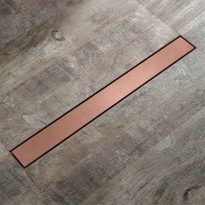 Copper-colored 60cm rose gold bathroom floor drain strainer with sleek modern design set into gray wood-grain flooring