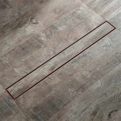 A sleek 60cm rose gold bathroom floor drain strainer with stainless steel design embedded in gray wood flooring