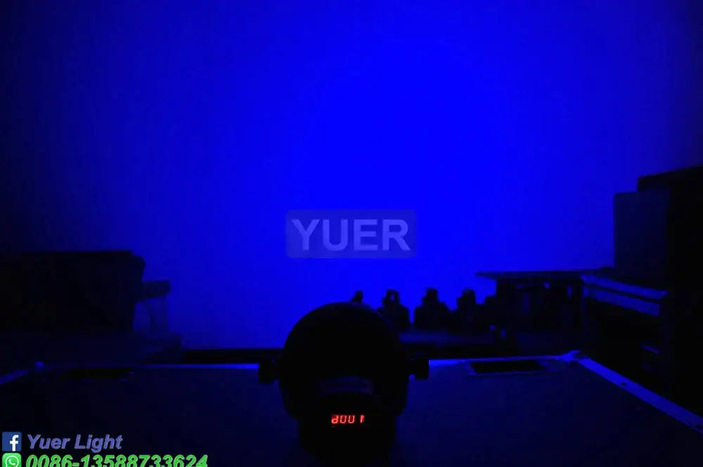 Blue illuminated stage featuring the yuer logo with decorbites™ 60w cob led par light with barn doors and dmx controller