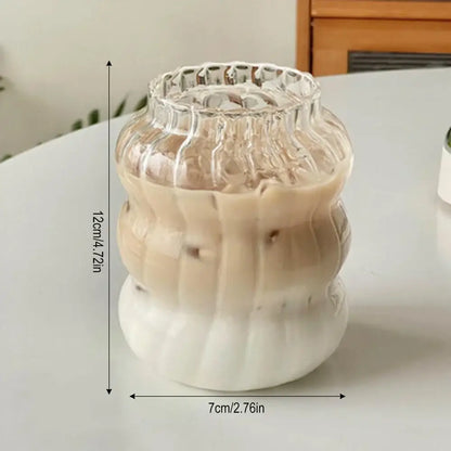 Clear ribbed glass tumbler with white ceramic base containing gradient iced coffee in decorbites 650ml latte ribbed glass