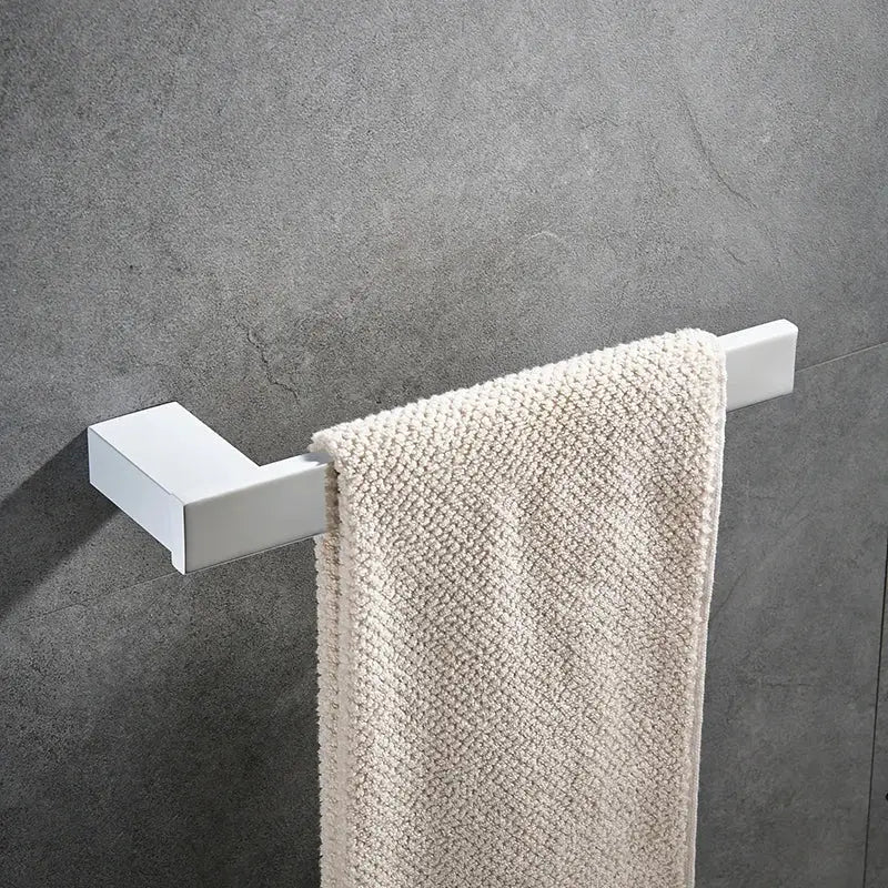 White rectangular towel rack holding cream textured towel in DecorBites bathroom hardware set for towels and toiletries