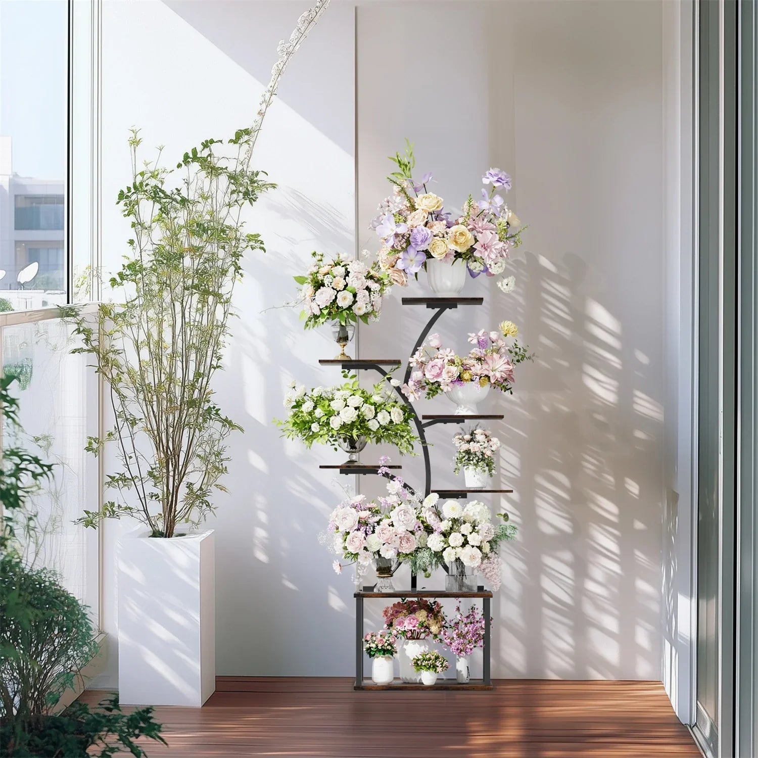 Modern black metal 7 tier plant stand display rack with white, lavender, and pink floral arrangements in various pots