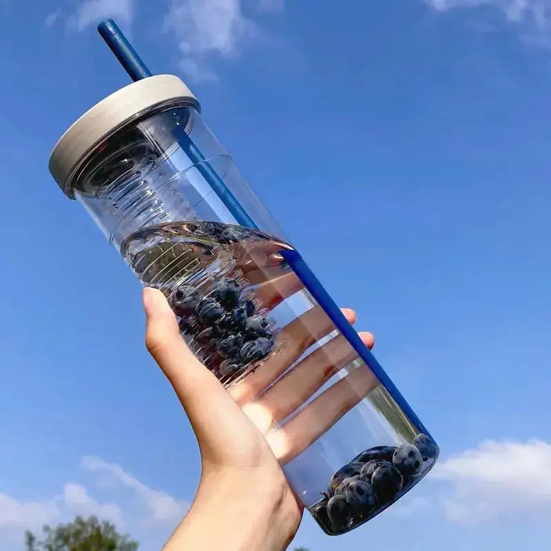 Clear plastic decorbites 700ml filtered water bottle with beige lid blue straw filled with water and dark berries