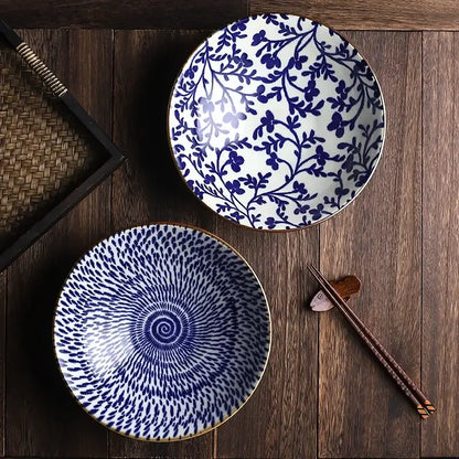 Two ceramic japanese ramen bowls with blue and white patterns and gold rims for soup salad or rice
