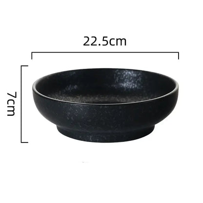 A sleek matte black retro ceramic ramen noodle bowl with speckled texture and rounded edges for soup and pickled cabbage