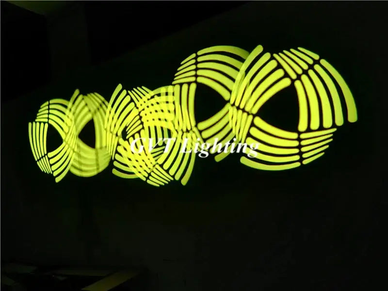 Vibrant neon yellow illuminated wall art with interlocking circular patterns created by decorbites 90w moving head light