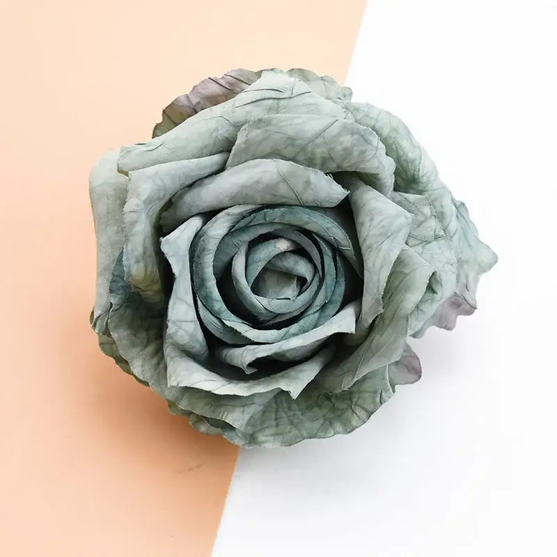 A delicate pale green 9cm silk rose with intricately folded petals from decorbites artificial flowers collection