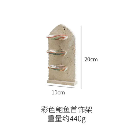Beige ceramic decorbites abalone shell jewelry organizer with three tiered shelves holding colorful shell ornaments