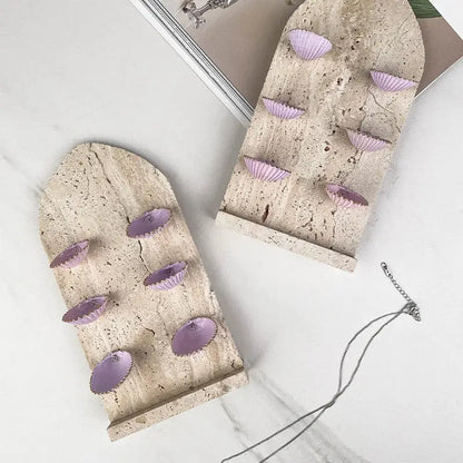 Two arched beige stone jewelry organizers with lavender abalone shell-shaped indentations decorbites abalone shell