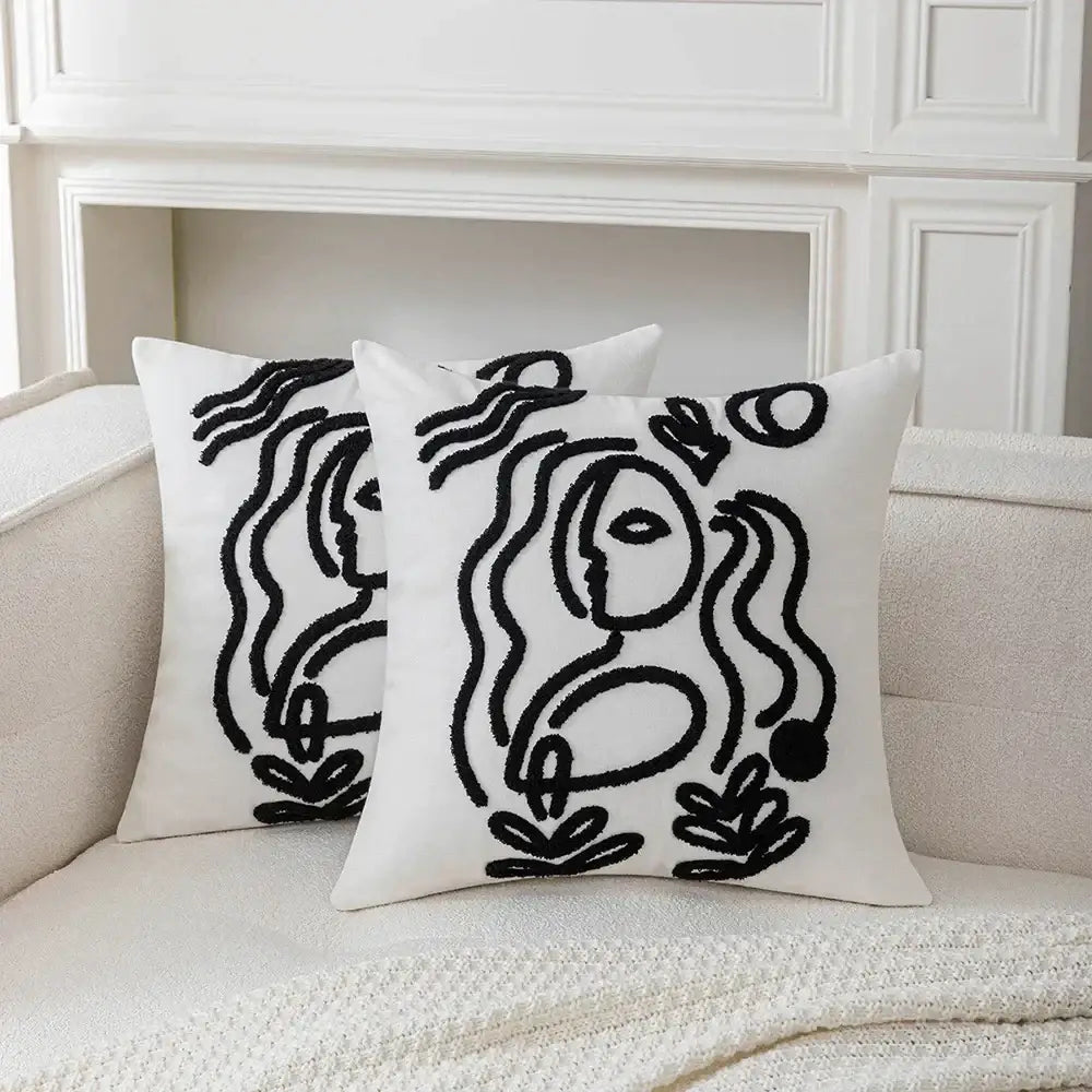 White plush cushion cover with black embroidered abstract art line designs by decorbites featuring stylized faces