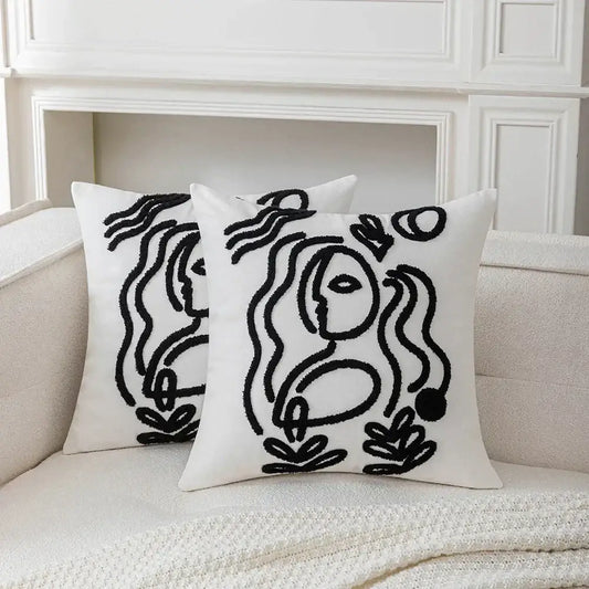 White plush cushion cover with black embroidered abstract art line designs by decorbites featuring stylized faces