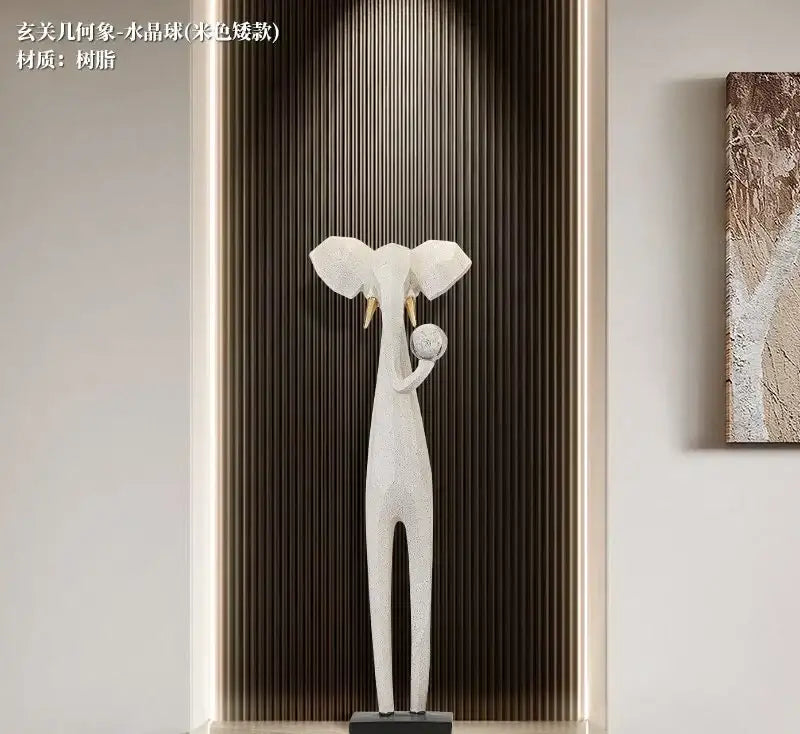 White resin elephant sculpture with gold tusks holding a sphere for modern living room decor bites abstract art cabinet