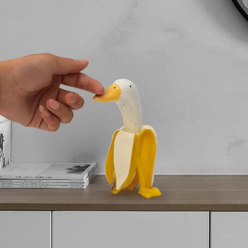 A whimsical white and yellow abstract banana duck sculpture decorative figurine made of smooth resin for home decor