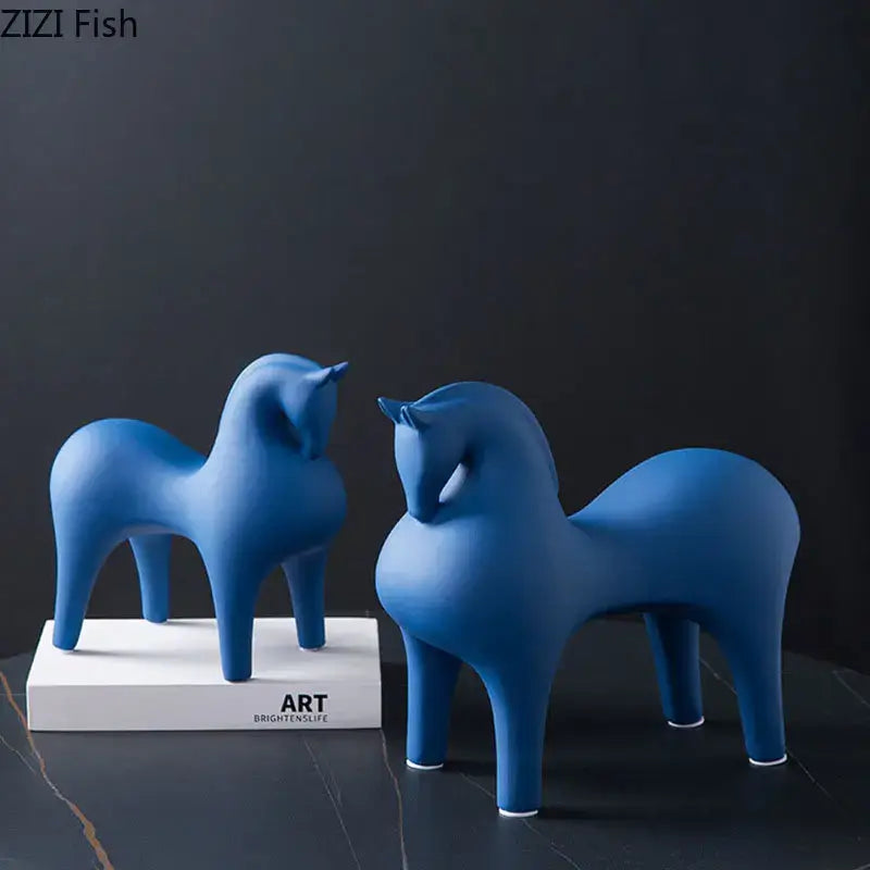 Two sleek matte blue decorative figurine horses with minimalist decorbites abstract ceramic design and white bases