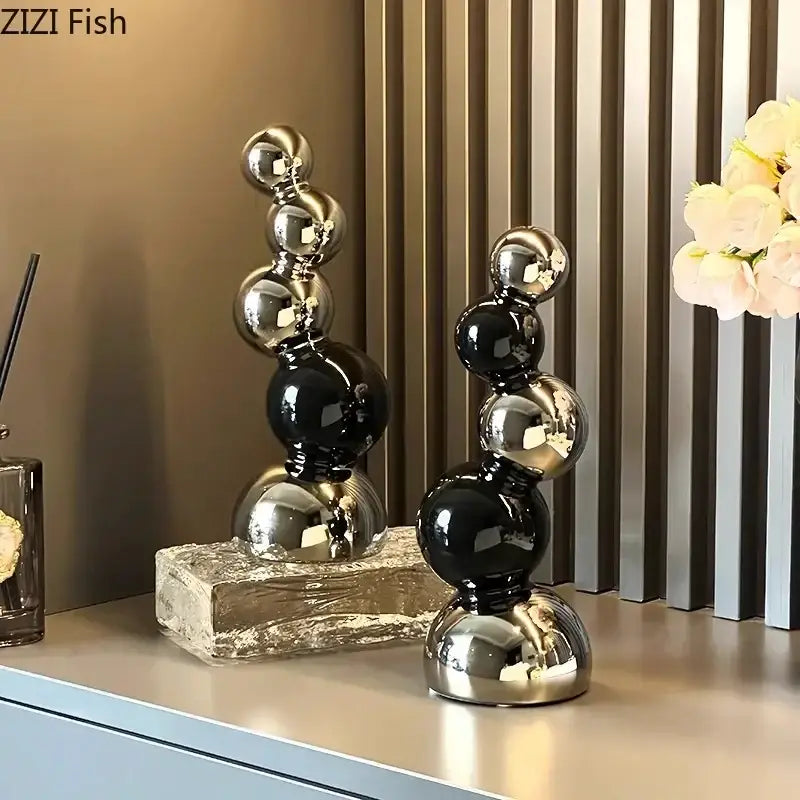 Two sleek decorbites abstract ceramic sculpture ornaments with alternating black and silver spheres on stone bases