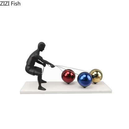 Decorbites abstract character metal sculpture of a black man pulling red blue and gold reflective spheres with wires