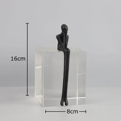Black matte decorbites abstract character sculpture with elongated limbs on a clear crystal base for modern decor