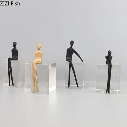 Minimalist decorbites abstract character sculpture in black and gold seated on a clear crystal base for modern decor