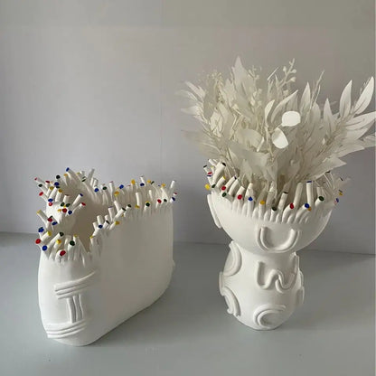 White ceramic decorbites abstract coral shapes flower pots filled with colorful pencils and delicate white paper flowers