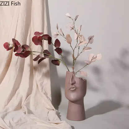 A matte mauve decorbites abstract face ceramic vase shaped like a stylized human head for table flower decoration