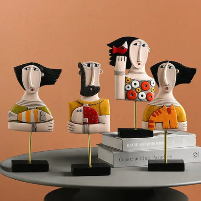 Stylized decorbites abstract face resin art ornament figures with bold black hair colorful patterns and gold stands