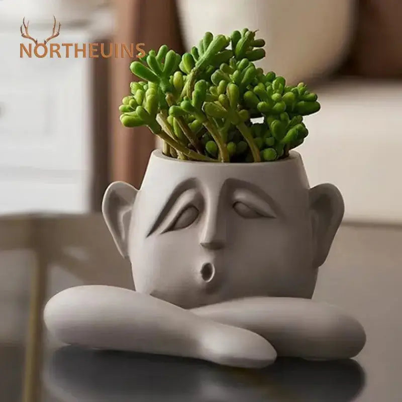 Gray ceramic flowerpot ornament shaped like a sleeping face holding green succulents decorbites abstract family flowerpot