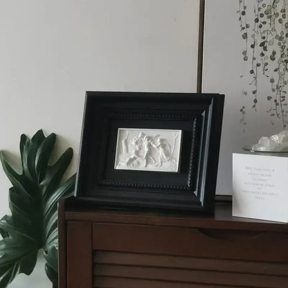 Black framed white relief sculpture featuring two abstract figures in a dynamic scene decorbites abstract figure decorative painting