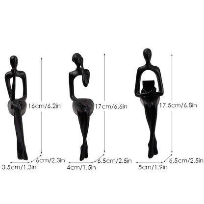 Set of three black decorbites abstract figurines with smooth glossy finish in minimalist seated human form for home and office