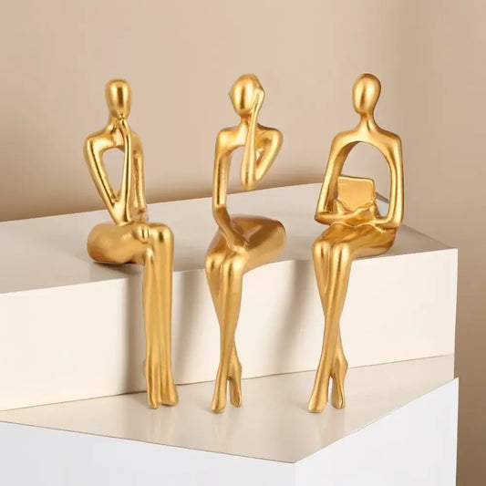 Three sleek golden decorbites abstract figurines set with minimalist metallic finish for modern home and office decor