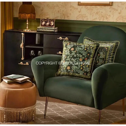 Deep emerald green velvet armchair with gold-tone legs and DecorBites accent pillow case featuring acanthus scroll leaves design