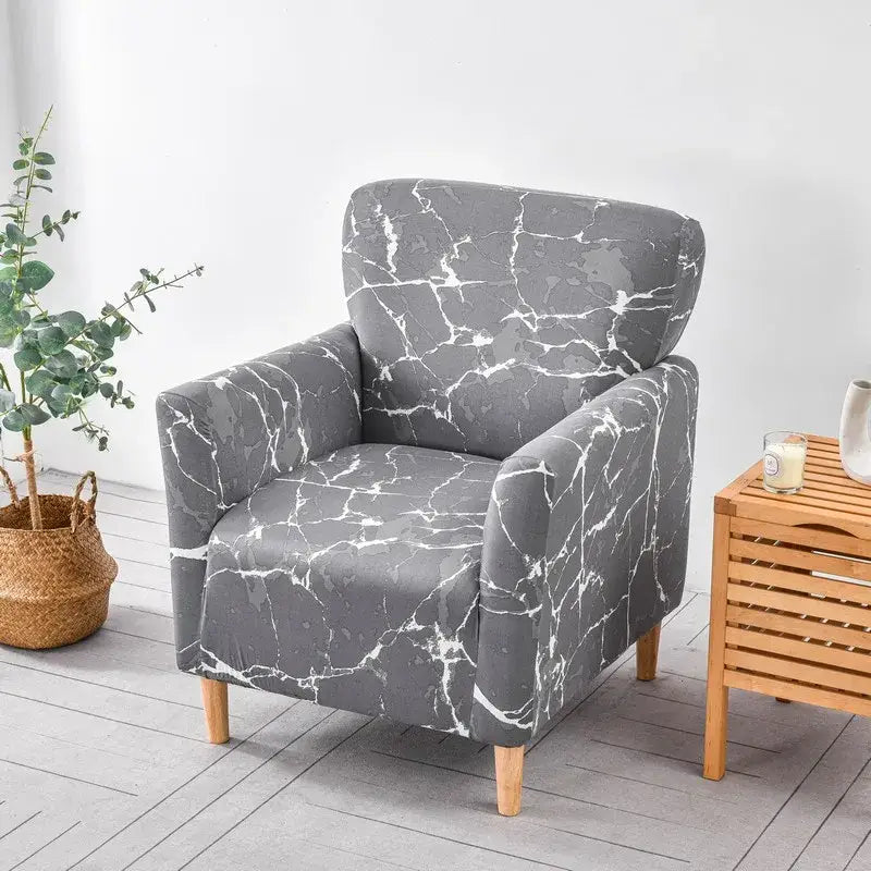 Gray accent chair covered with a white marble pattern DecorBites™ stretch fabric accent chair cover slipcover